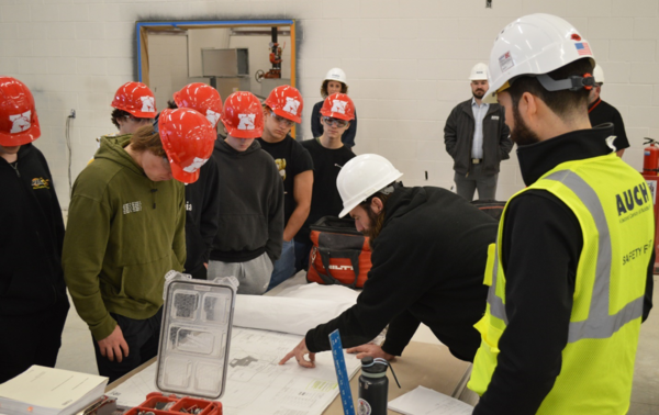Students looking at blueprint for construction trades building