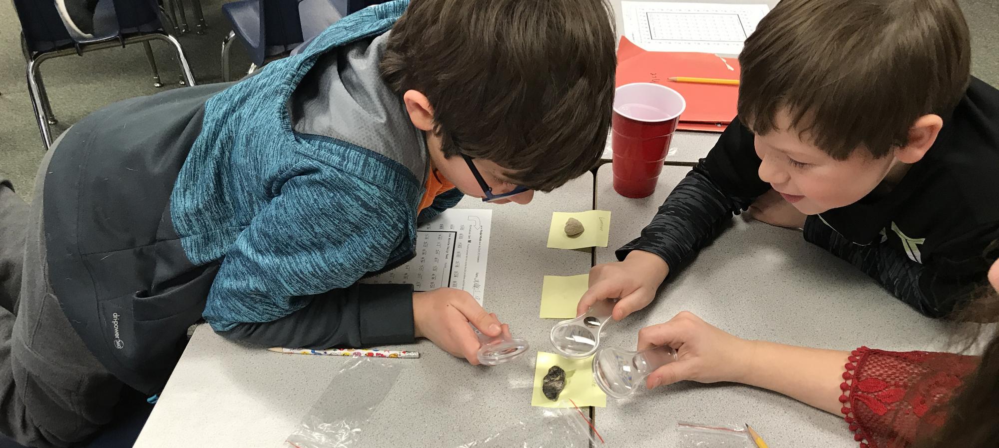 Students in science class looking at stones