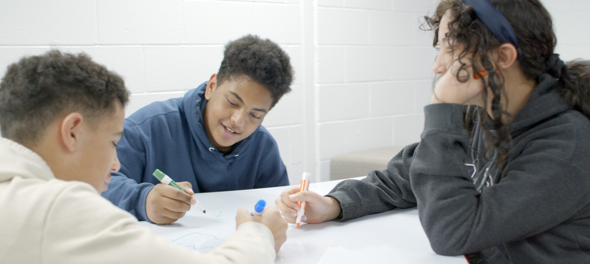 Students working on whiteboard desk