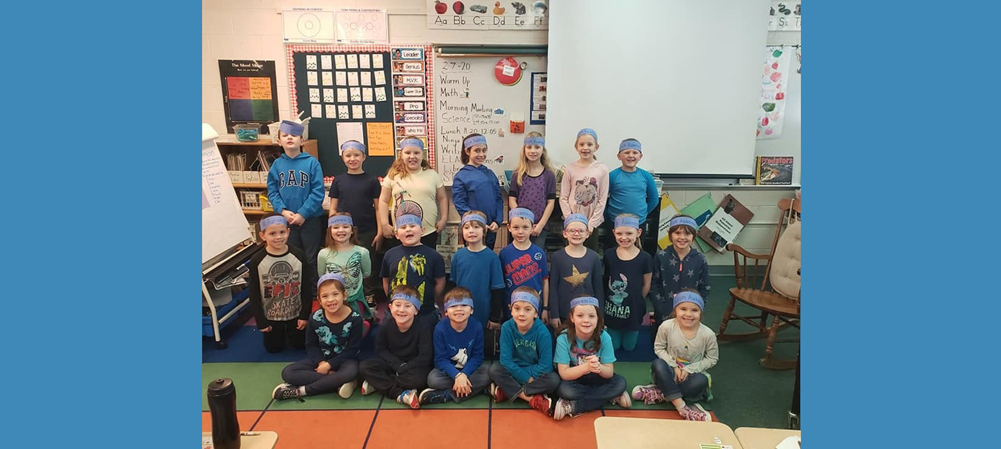 Students in class with head bands that say Autism Awareness