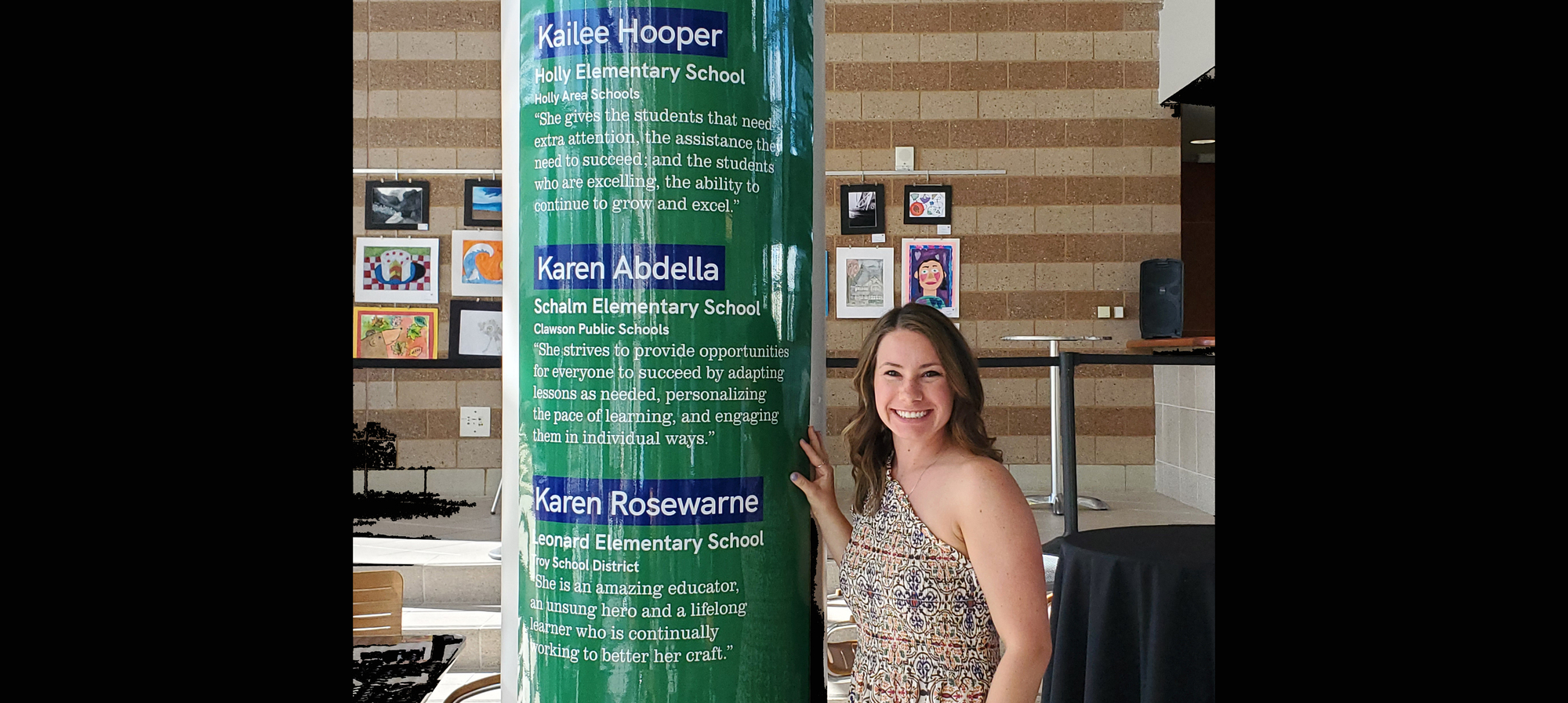 Mrs. Hooper by a pilar with her name and information about why she was nominated.