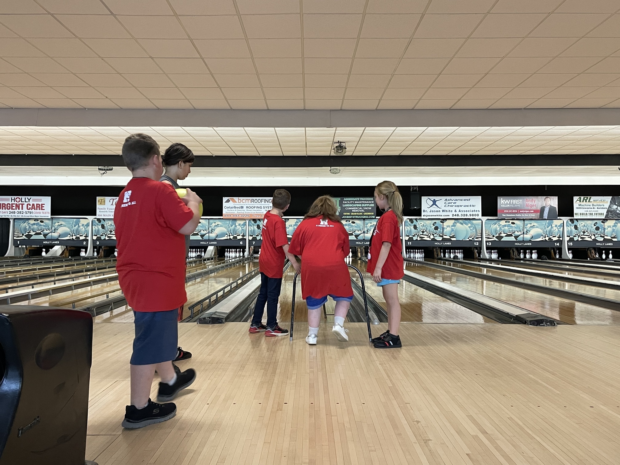Students helping another student to bowl