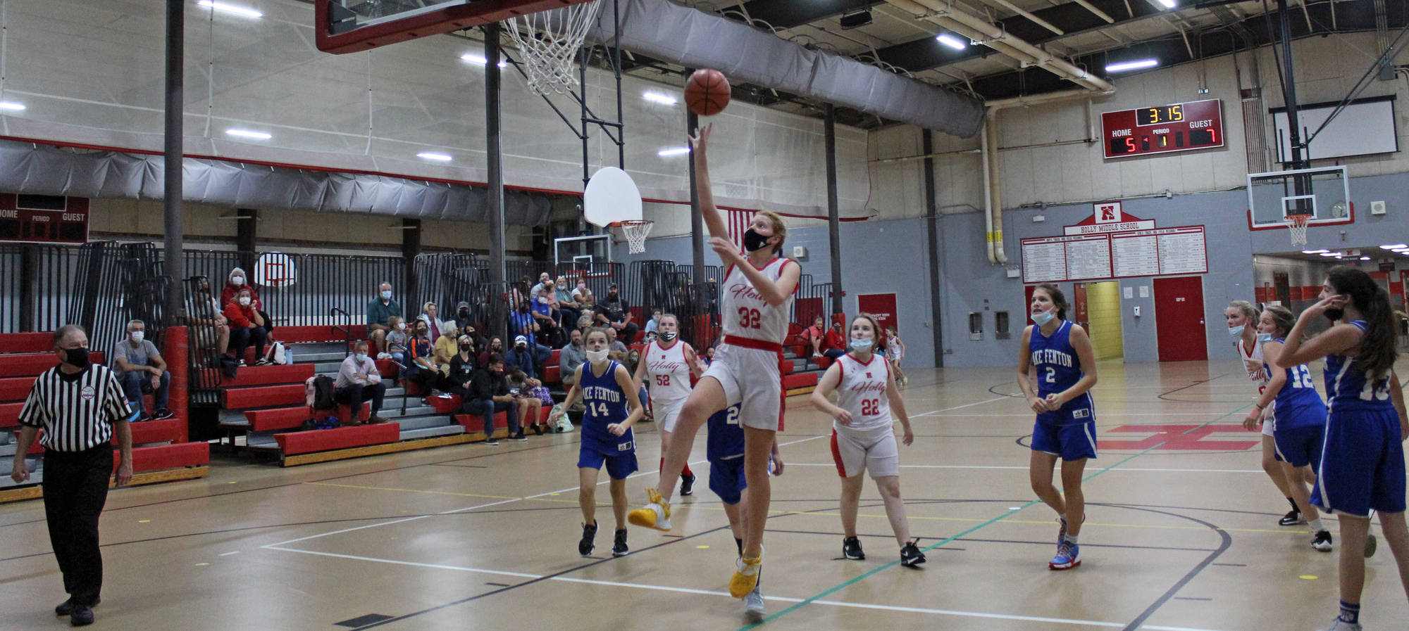 Female girls basketball game with student making a layup