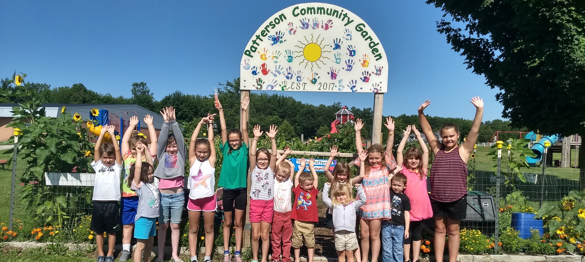 Students in front of the community garden sign