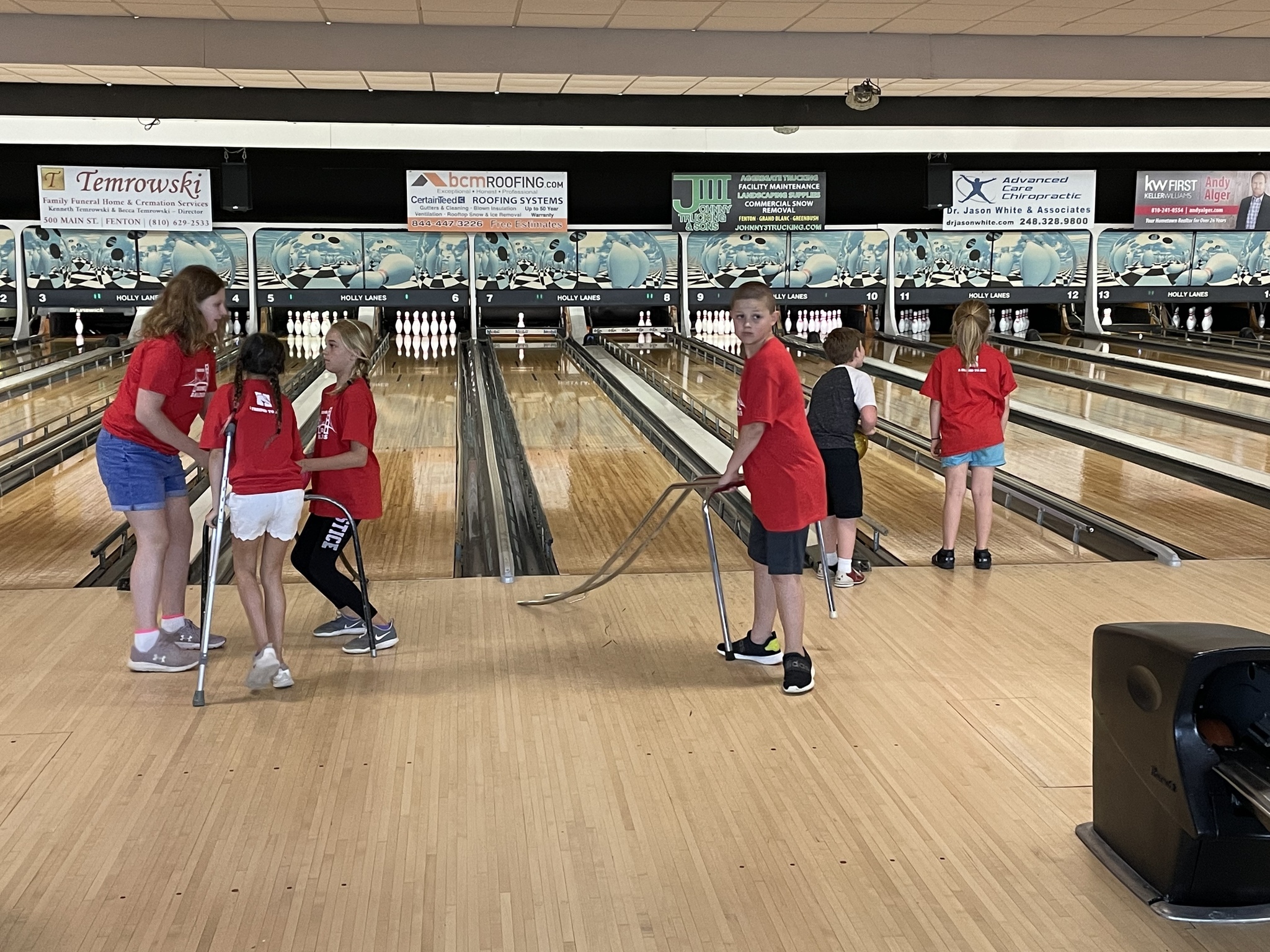 Students assisting other students at the bowling alley