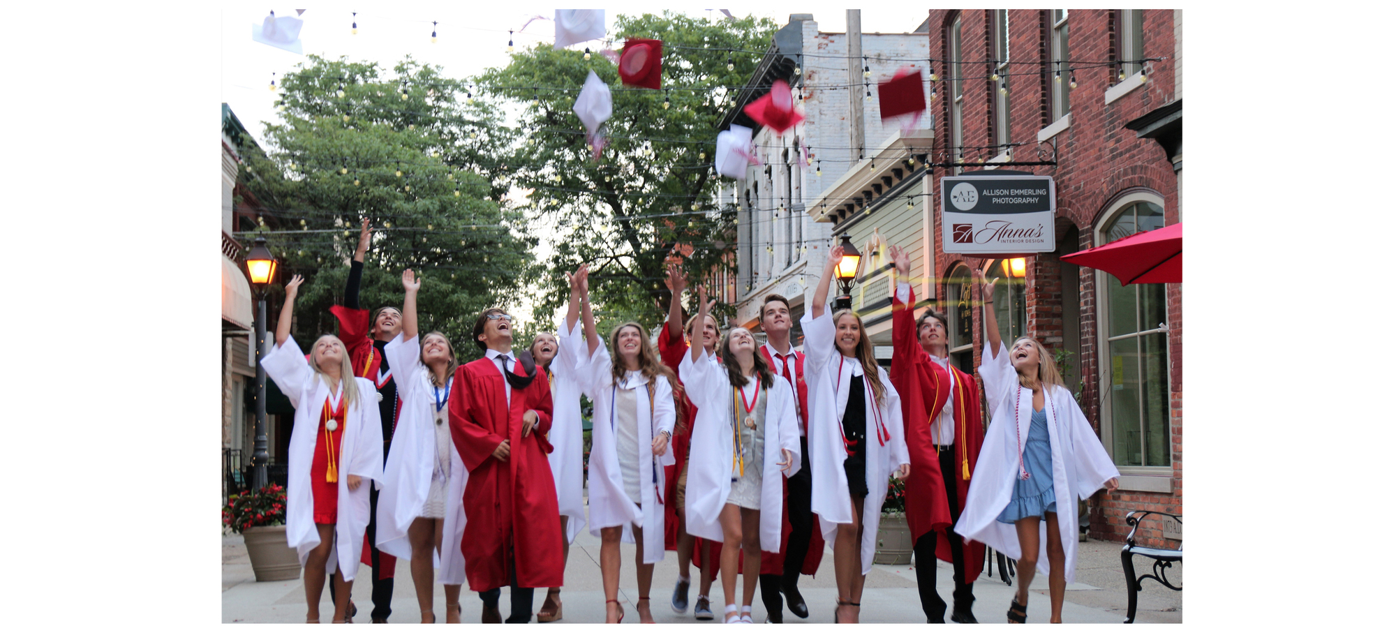 A group of students in their graduation gowns throwing their caps in the air