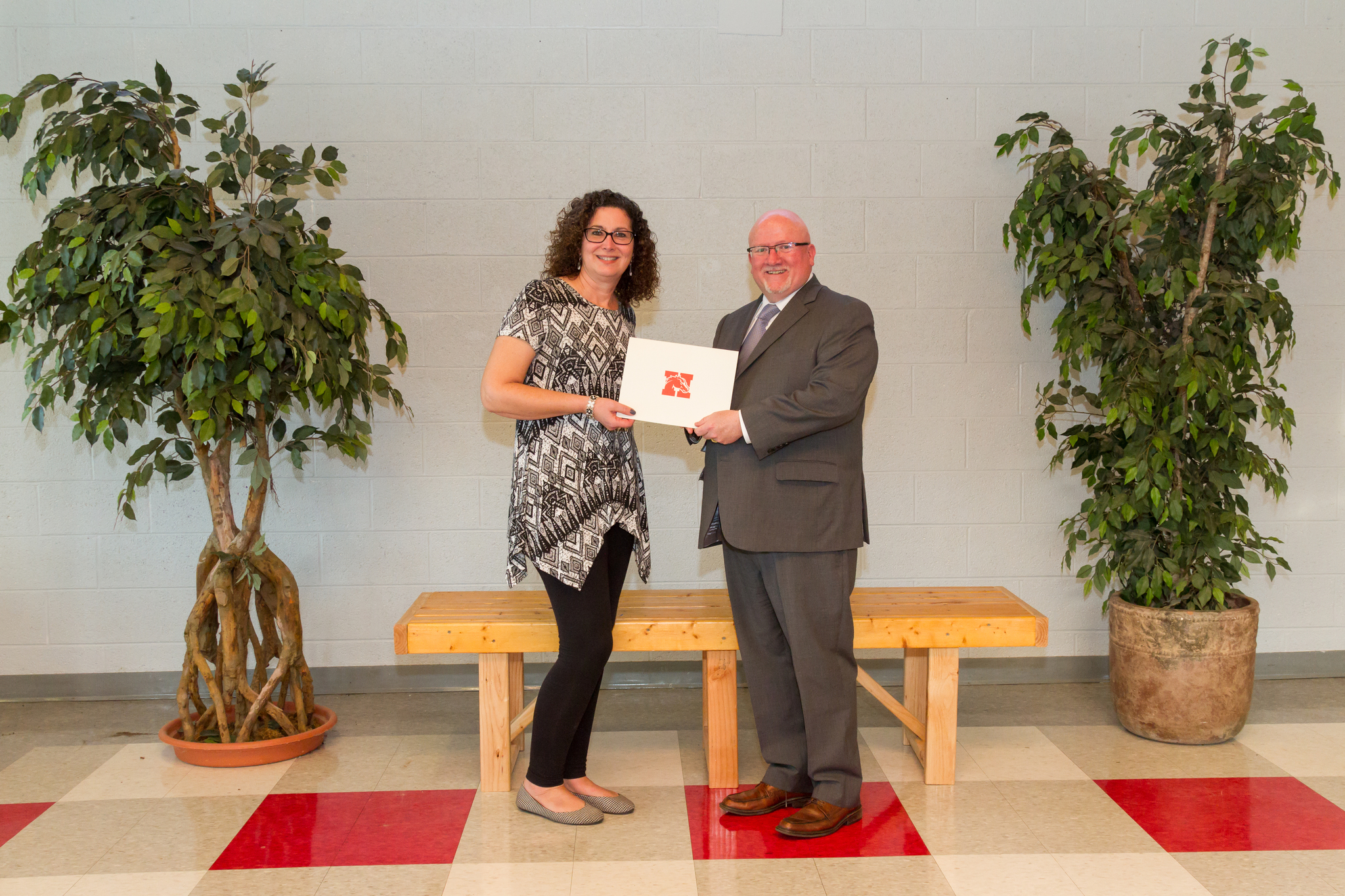 Mrs. Postma and the Board President holding award