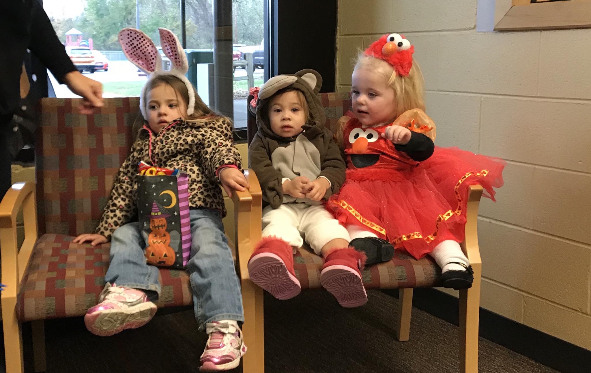 Three early on students, a bunny, a monkey, and elmo