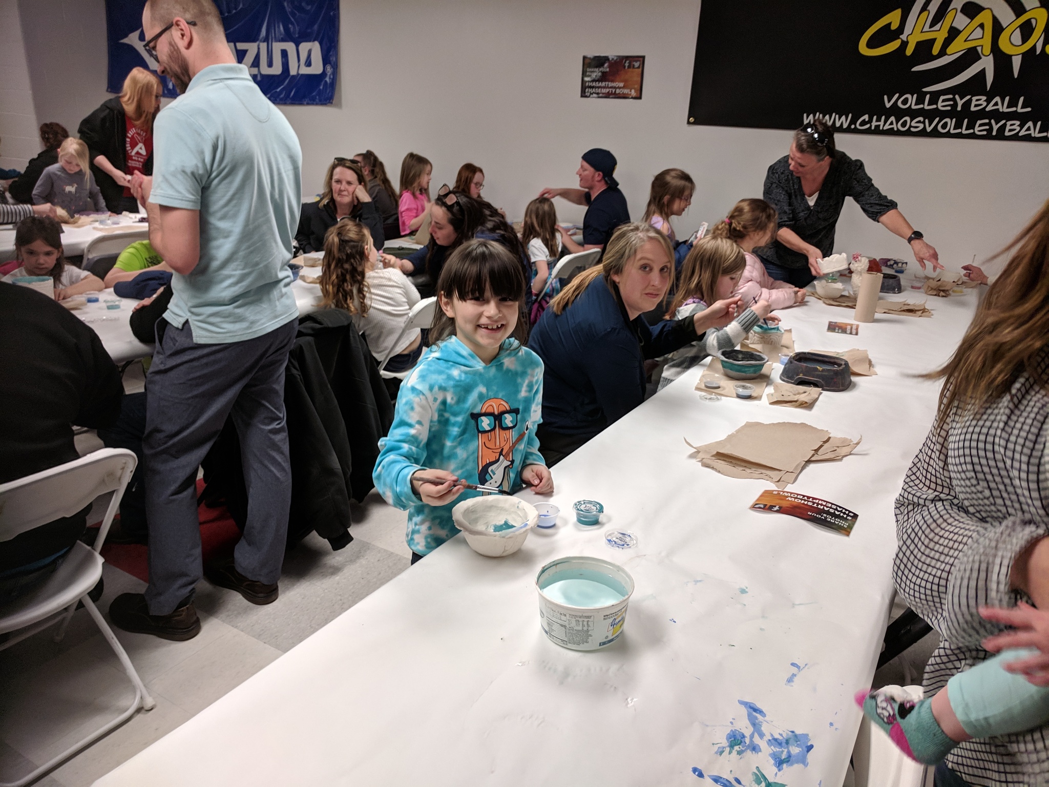 Parents and students painting bowls