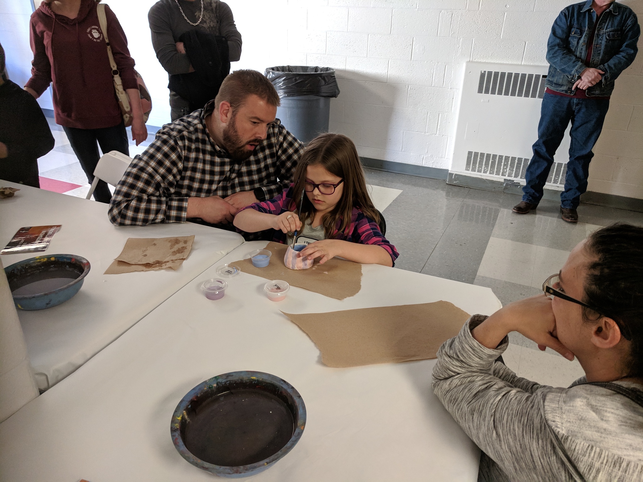 Parents and students painting empty bowls