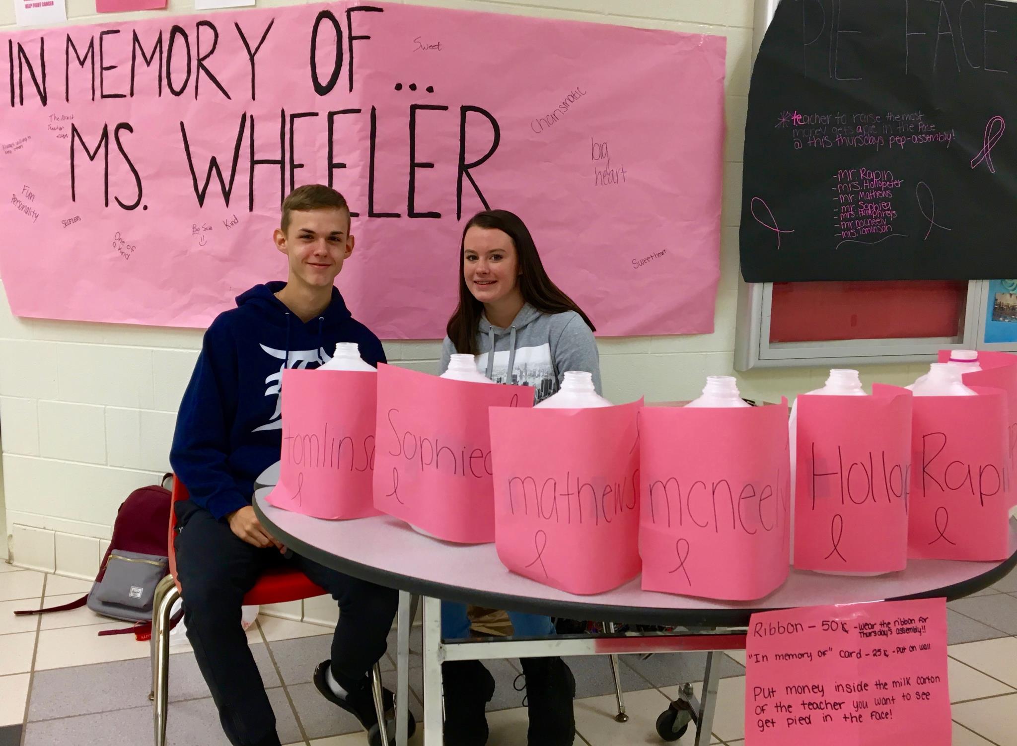 Fundraiser sign in memory of Mrs. Wheeler and kids with donations cans