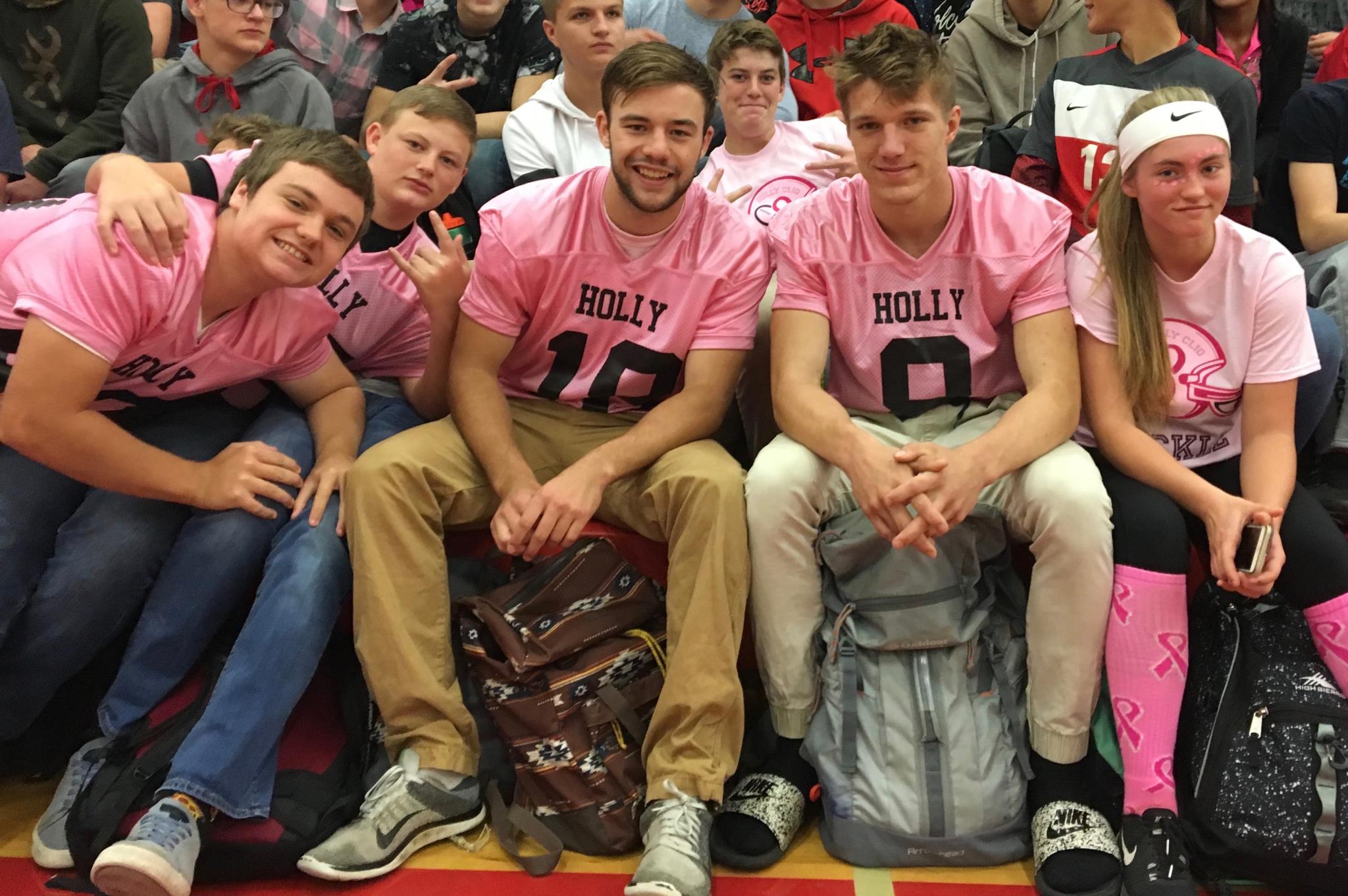 Boys in the stands at the pep assembly for the pink game