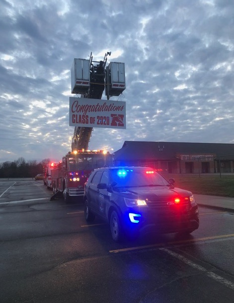 Fire truck with sign - congratulations Class of 2020 police car and ambulance with lights going