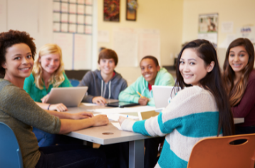 Small group of high school students working together on computers.