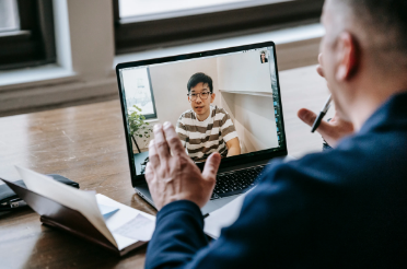 Mentoring Image man using laptop with student image on screen