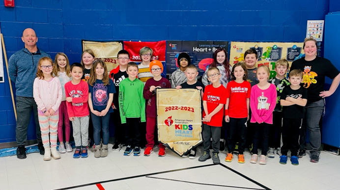 Holly elementary school students pose after raising more than $6,000 to help families with loved ones facing heart illnesses.