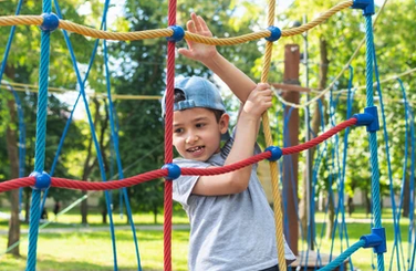Boy climbing on net outside