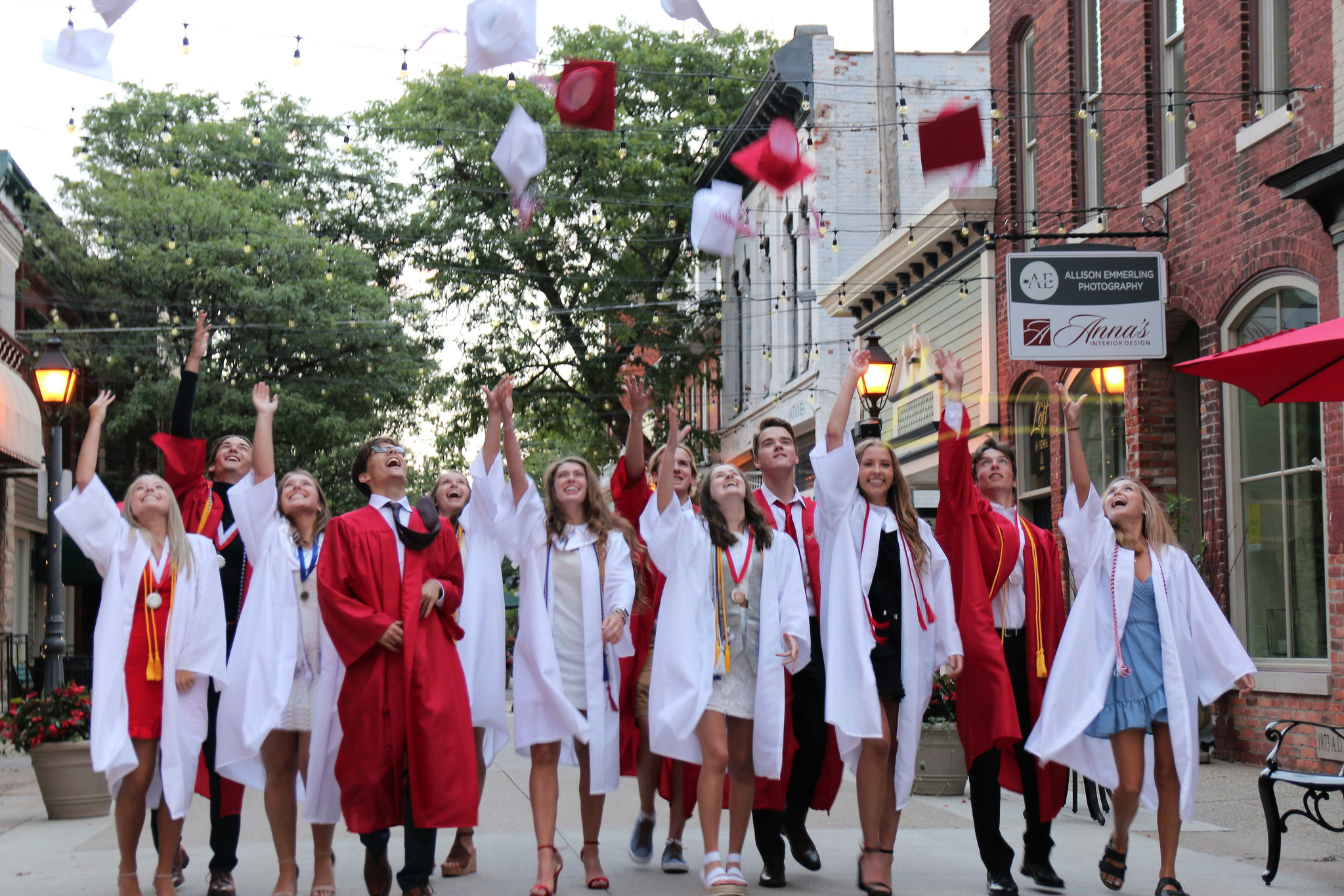 A group of students walking and throwing their graduation caps in the air